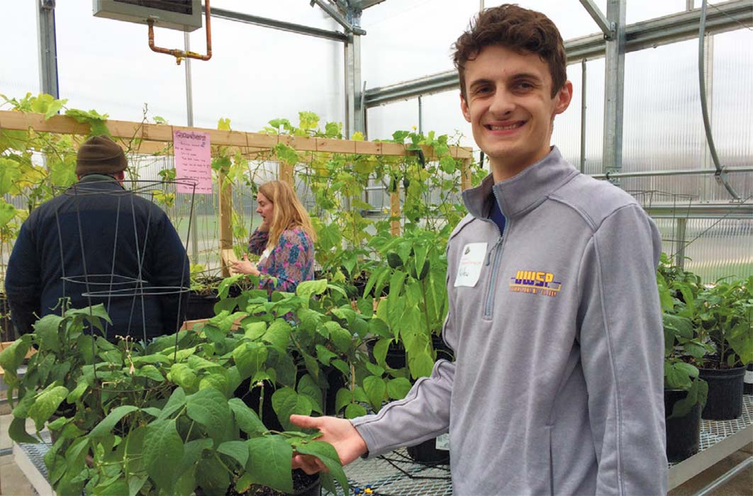 Sustainability Living class student Matthew Moxon in the greenhouse at Sturgeon Bay High School.